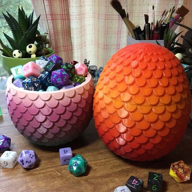 Customer review photo of two colorful dragon egg D&D dice boxes full of dice.